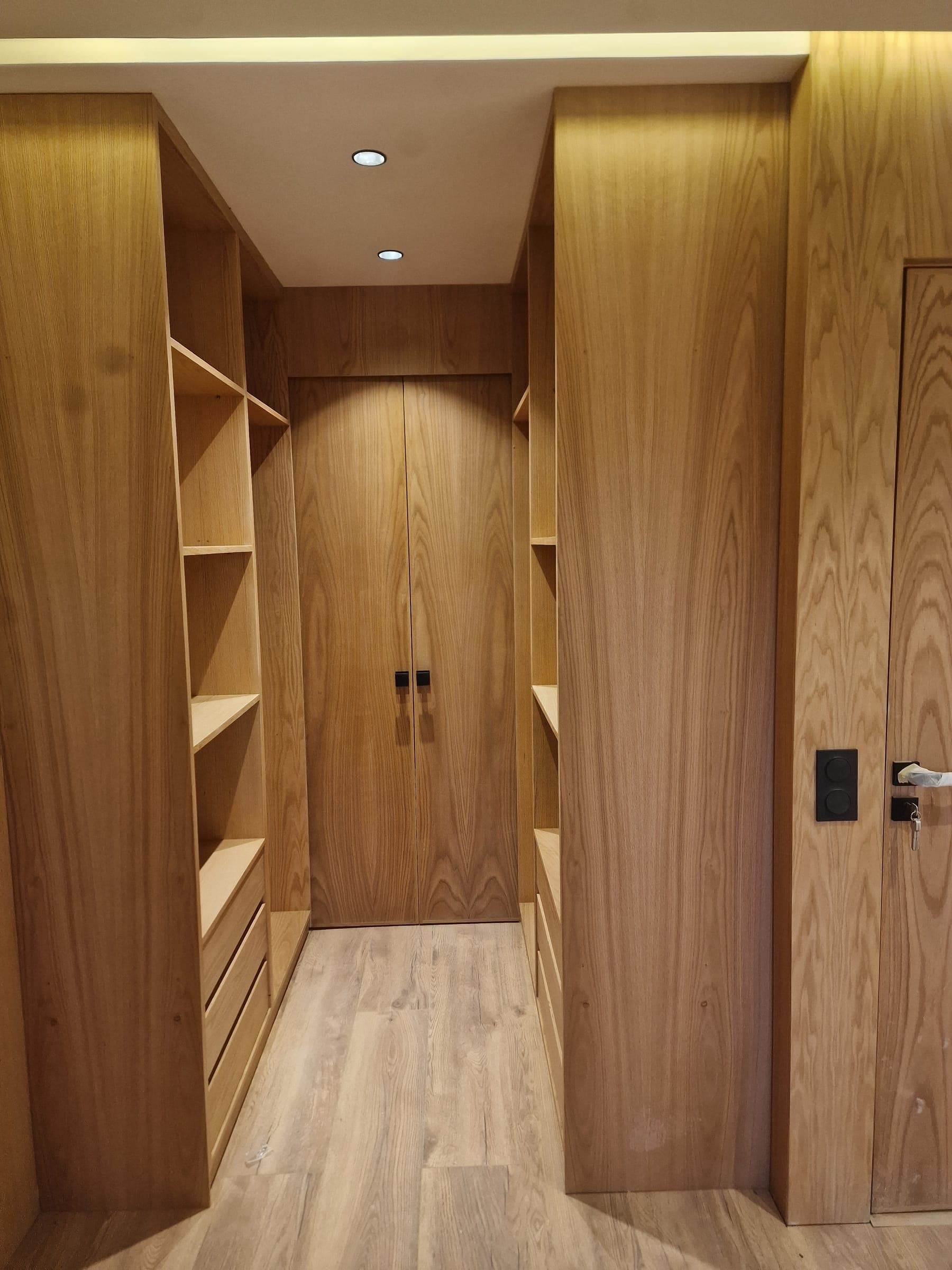 Dressing en bois clair avec éclairage intégré et porte assortie