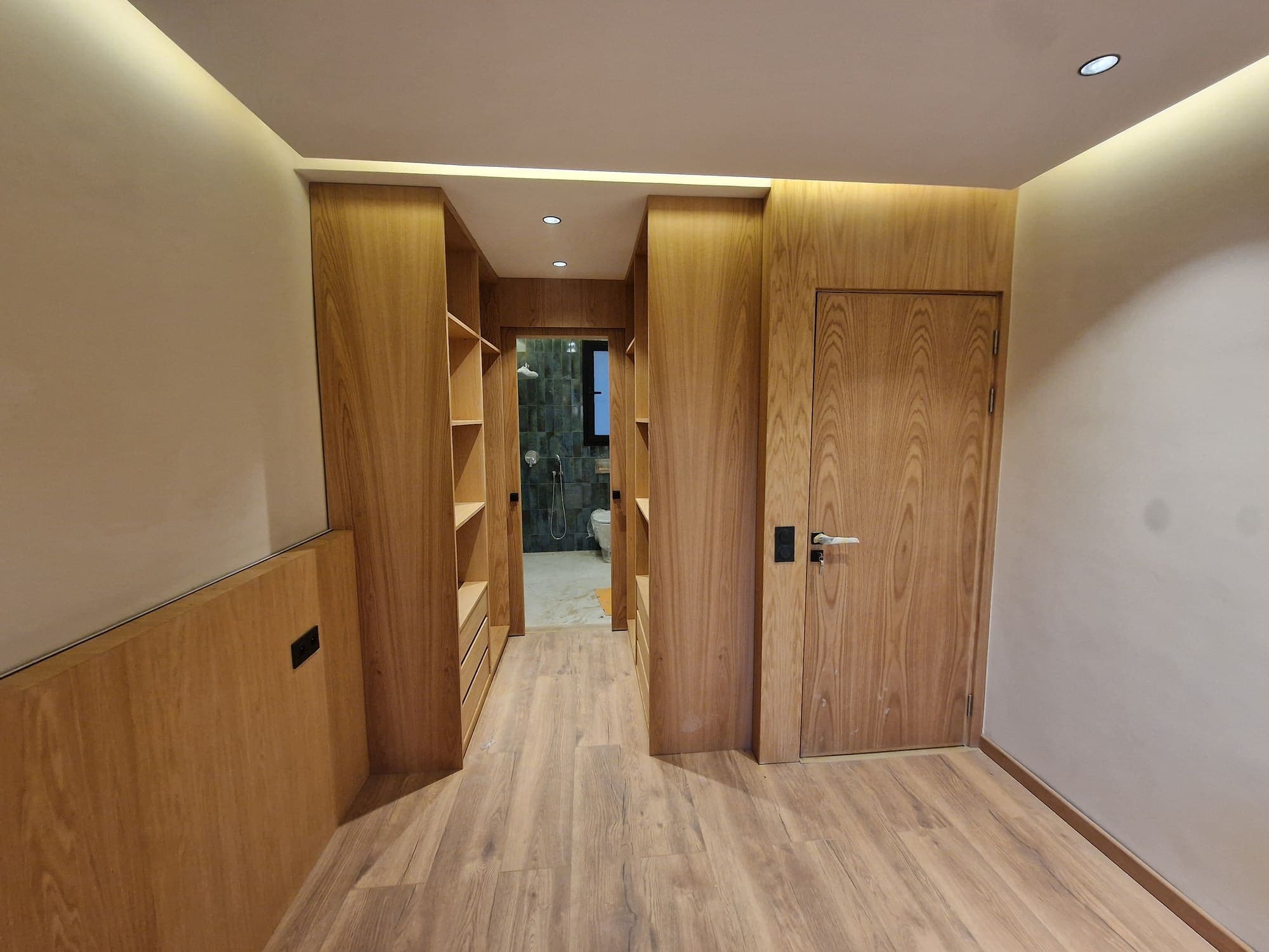 Couloir avec porte en bois, habillage mural et rangements intégrés