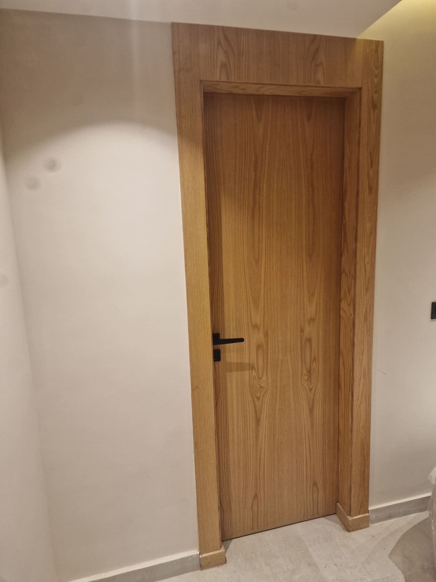 Porte intérieure en bois clair à poignée noire