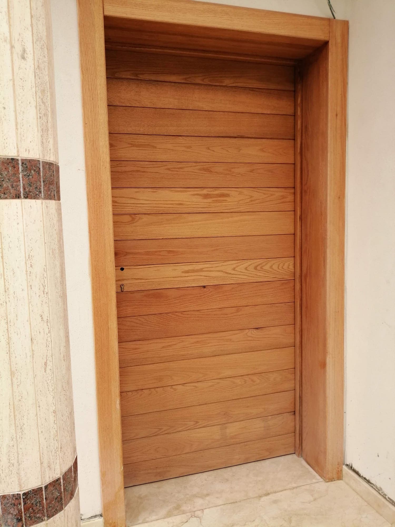 Porte en bois à lames horizontales et encadrement en bois