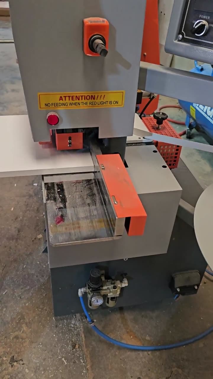 Une plaqueuse de chants pose la bande de finition sur le bord d’un panneau dans l’atelier