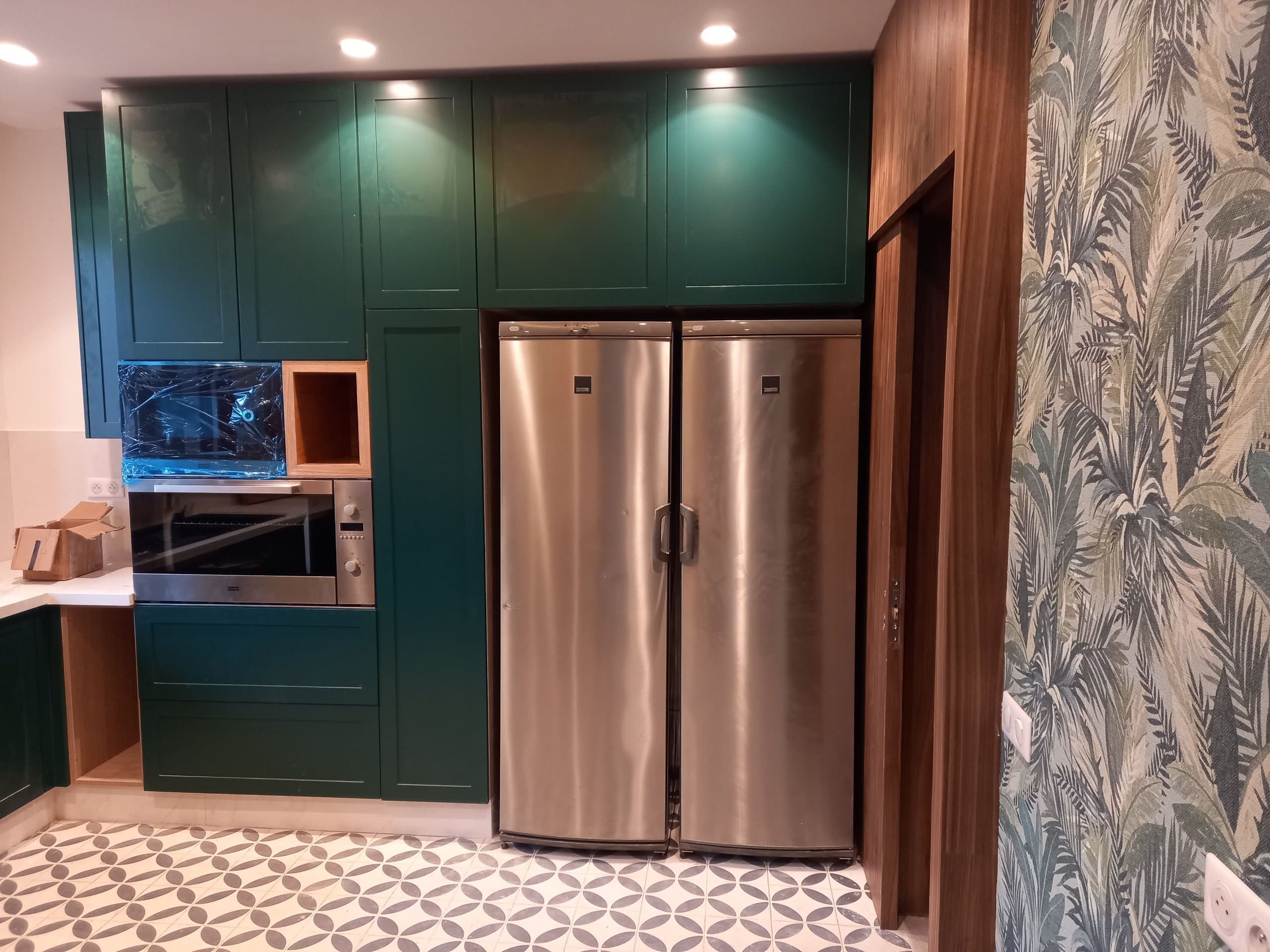 Meubles hauts à façades vertes au-dessus de deux colonnes réfrigérées encastrées, cuisine à Agadir